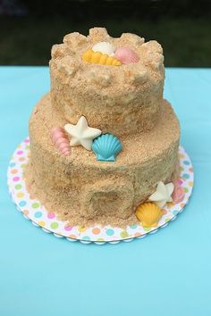 a three tiered cake with seashells and starfish decorations on the top