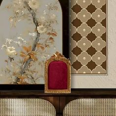 an ornate wall hanging next to a chair with a red cushion on top of it