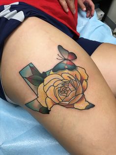 a woman's thigh with a yellow rose tattoo on her lower leg and an arrow in the middle