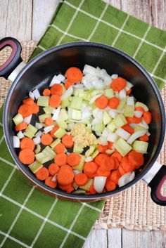 carrots, celery and onions are being cooked in a pan on the table