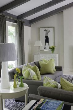 a living room filled with furniture and a painting on the wall above it's fireplace