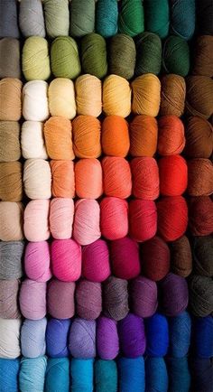 many skeins of yarn are arranged in different colors and sizes, including multi - colored