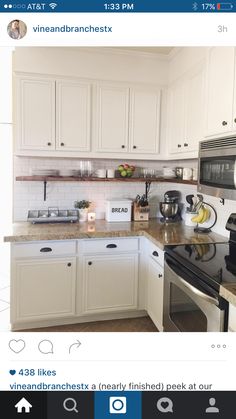 a kitchen with white cabinets and black appliances