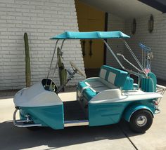 a blue and white golf cart parked in front of a building