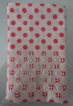 a white and red polka dot fabric with pink dots on it, sitting on a table