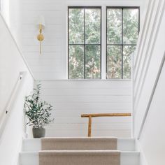 the stairs in this house are lined with white painted walls and wood trimmings