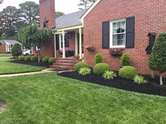 a brick house with black mulch landscaping