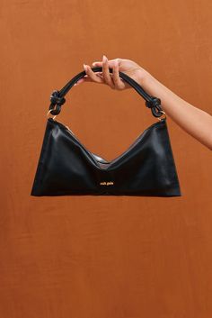 A redesigned classic leather shoulder bag with a knotted strap and slouchy silhouette. — Shoulder bag — Knotted strap — Zipper closure — Smooth leather Swimming Bag, Cult Gaia, Kids Sandals, Mini Shoulder Bag, Classic Leather, Leather Jewelry, Kids' Dresses, Platform Sandals, Smooth Leather