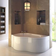 a large white bath tub sitting inside of a bathroom next to a wall mounted light