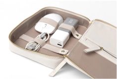 the inside of a white case with various items in it and an electronic charger plugged into each other