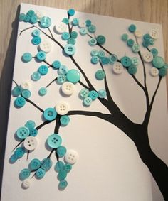 a tree made out of buttons on a white board with blue and white flowers painted on it