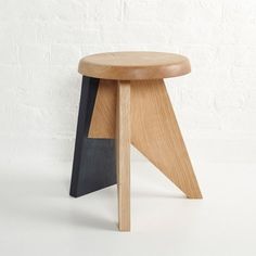 a wooden stool sitting on top of a white floor