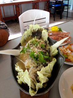 a table topped with plates and bowls filled with food next to a bowl of salad