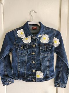 a denim jacket with white flowers on it