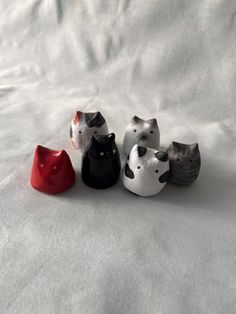 five small ceramic cats sitting next to each other