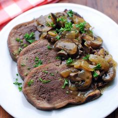 two steaks with mushrooms on a white plate