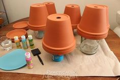 a bunch of clay pots sitting on top of a wooden table next to other items