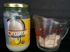 a glass measuring cup next to a jar filled with coconut oil