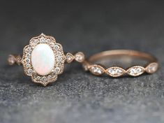 two wedding rings with white opal and diamonds on the top, one in yellow gold