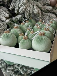 green christmas ornaments in a box on display