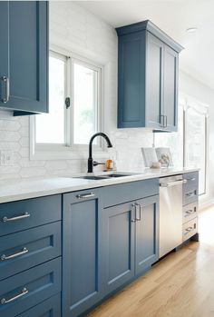 a kitchen with blue cabinets and stainless steel appliances