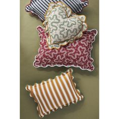 three pillows with decorative designs on them are laying next to each other and one has a striped pillow in the shape of a heart