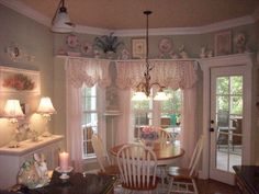 a dinning room table and chairs in front of two windows