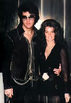 the man and woman are posing for a photo together in black outfits with sunglasses on