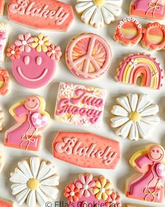 decorated cookies are arranged in the shape of flowers and peace, sun, and rainbows