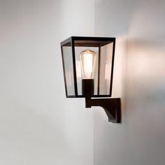 a light that is on the side of a wall next to a white wall in a room