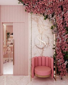 a pink chair sitting in front of a wall with roses on it and a mirror