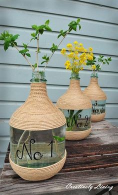 three vases with flowers in them sitting on a table