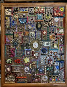 a wooden frame filled with lots of different types of necklaces and brooches