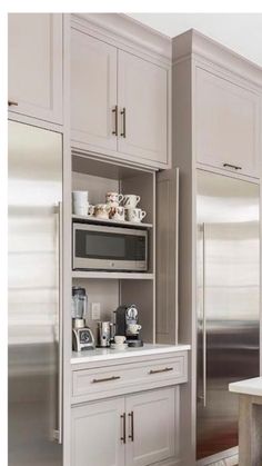 a kitchen with white cabinets and stainless steel refrigerator freezer combo in the center, along with an appliance that lets you know what's cooking