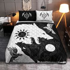 a bed with black and white comforters on it in a room next to a lamp