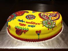 a yellow cake with red and blue decorations on it's side sitting on a silver platter