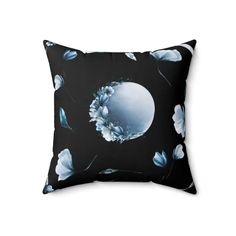 a black and white pillow with blue flowers on the front, and an oval mirror in the center