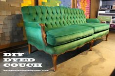 a green couch sitting inside of a room