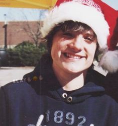 a young man wearing a santa hat and sweatshirt