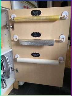 three different types of knives mounted on the back of a wooden cabinet in a shop