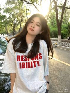 a woman standing on the side of a road wearing a t - shirt that says lessons ability