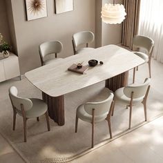 a dining room table with white chairs and a rug on the floor in front of it