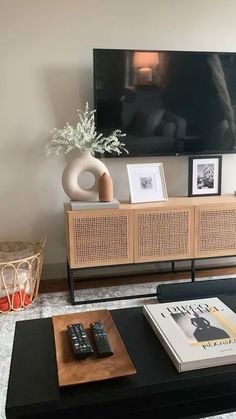 a living room with a large flat screen tv on top of a wooden entertainment center