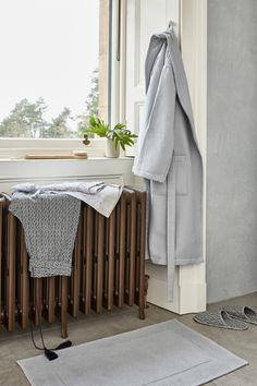 a bathroom with a radiator, towel rack and rug