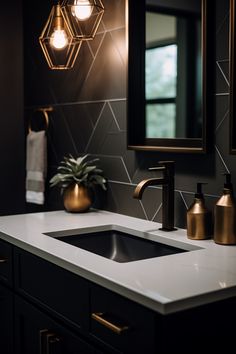 a bathroom sink with gold faucet and lights above it