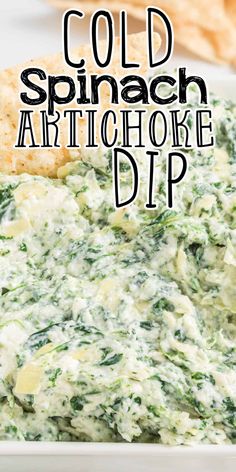 spinach artichoke dip in a white bowl with crackers on the side