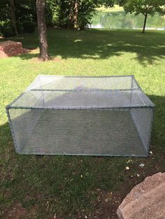 a large cage sitting on top of a grass covered field