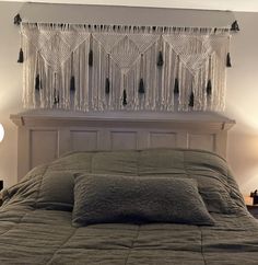 a bed with two lamps on either side and a curtain hanging over the headboard