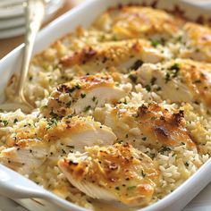 chicken and rice casserole in a white dish with silverware on the side