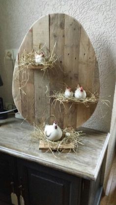 three small white birds sitting on top of a wooden shelf